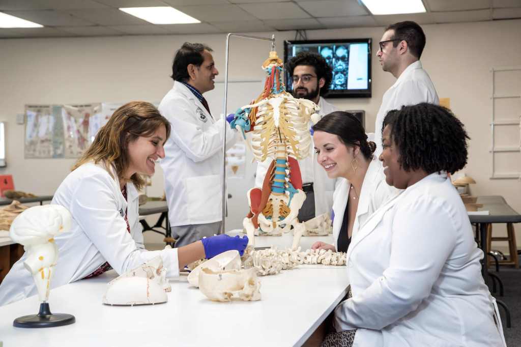 Students in their white coats, analysing a body