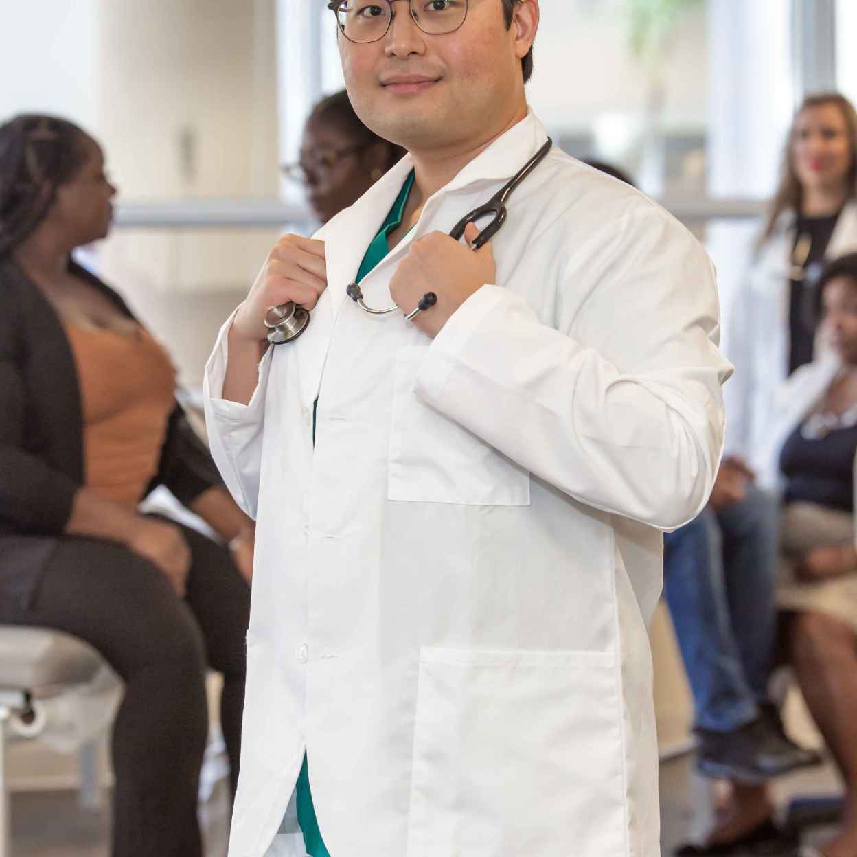 Wonjun Choi - SMU MED Student wearing his white coat in a classroom.