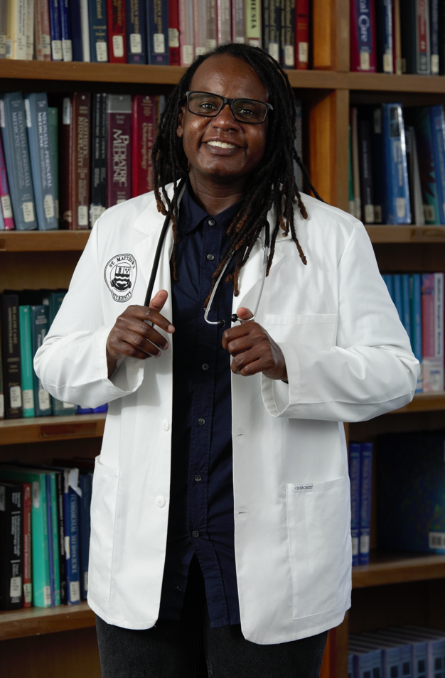 Tary Jordan - SMU Med current student, wearing his white coat, inside the library.
